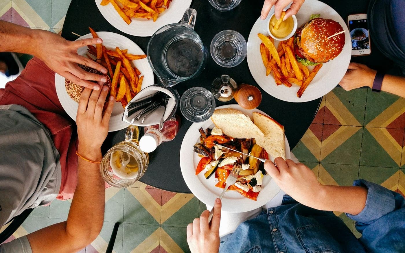 Friends sharing burgers and beers around a table