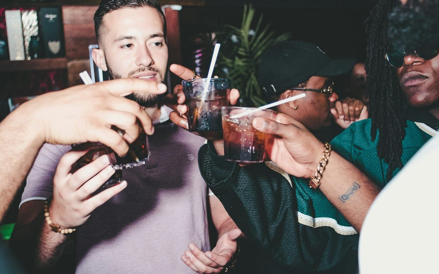 Friends clinking drinks together at a bar