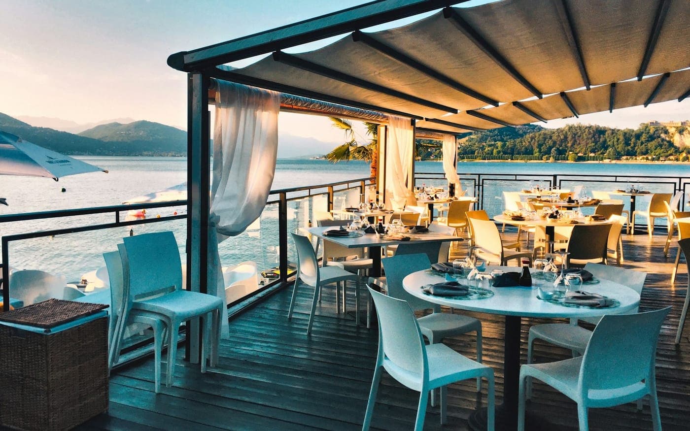 A waterside restaurant terrace at golden hour